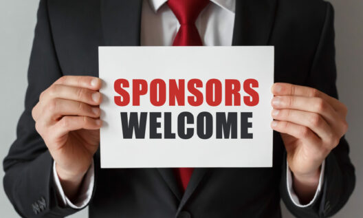 Businessman Holding A Card With Text Sponsors Welcome